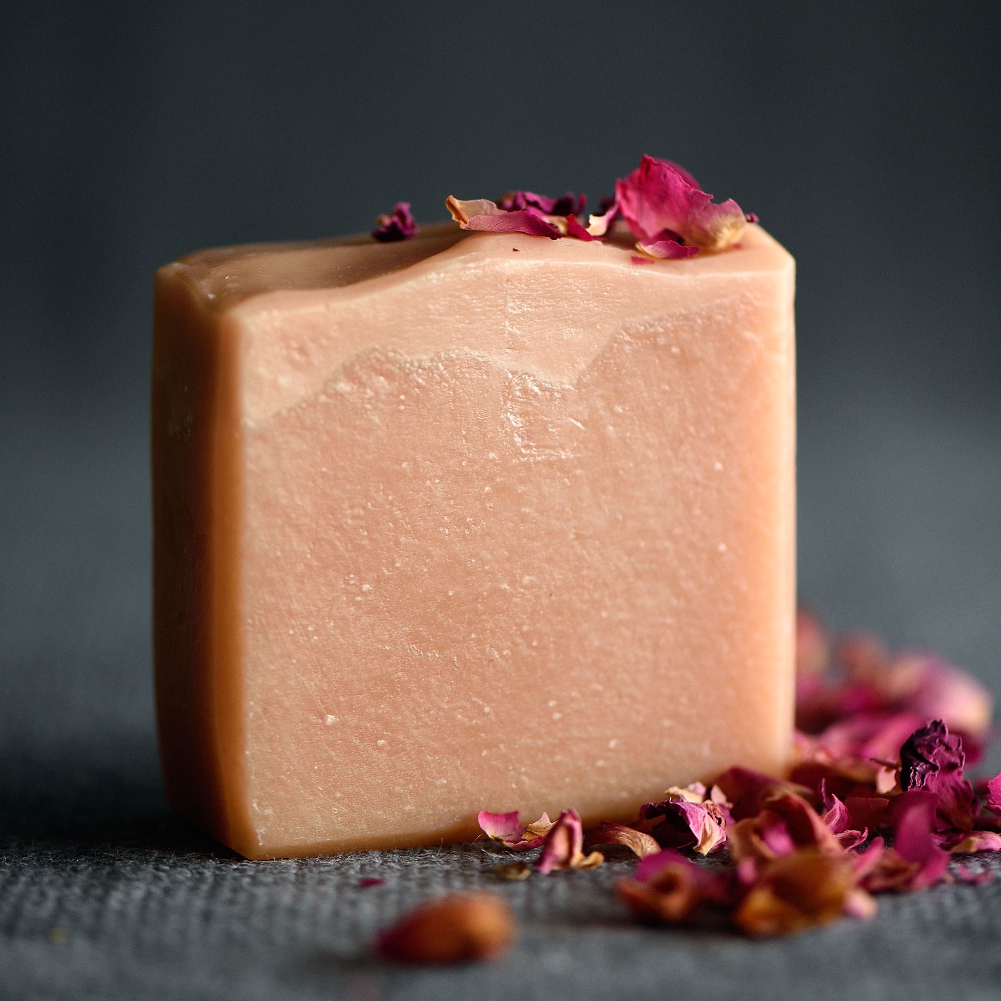 Gentle face soap bar displayed with delicate geranium petals